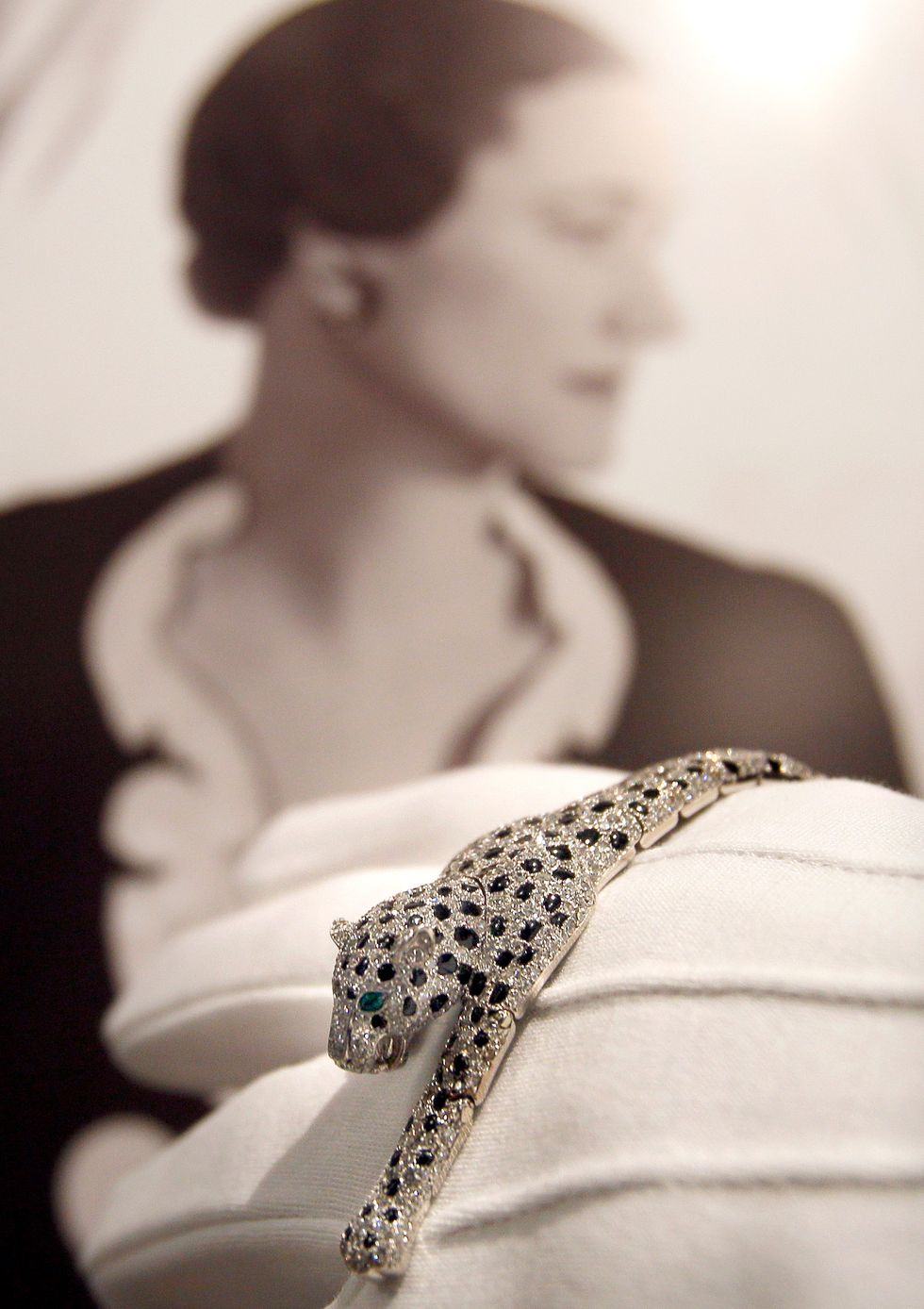 An onyx and diamond panthère bracelet seen displayed in front of a cecil beaton portrait of wallis simpson at sotheby’s auction rooms in london.
